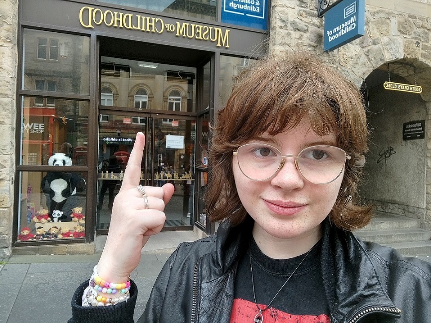 A young person stands outside the Museum of Childhood building