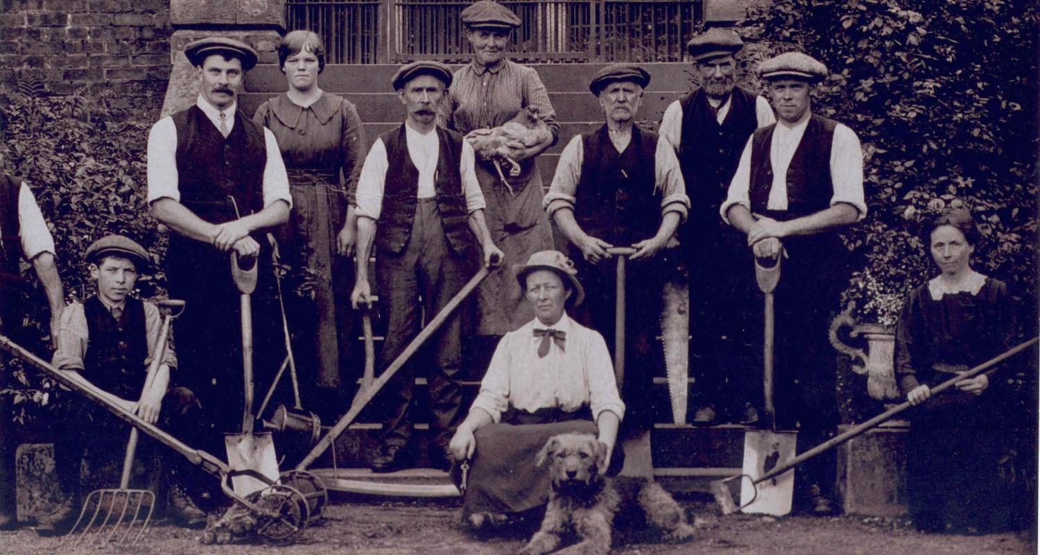 Mary Burton, her team of gardeners with shovels, hoes and garden forks, a chicken and her dog