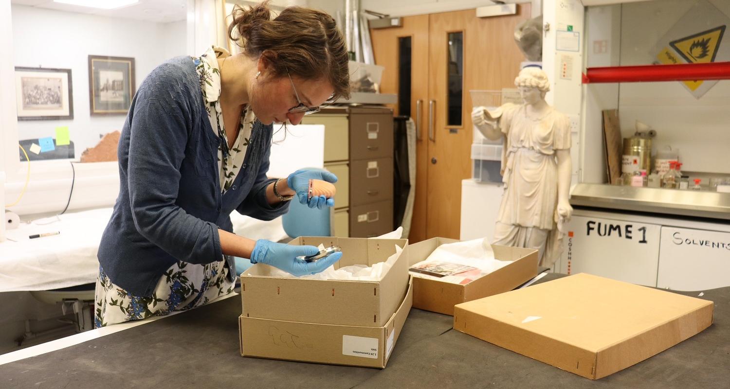 Keep the Faith project officer Miranda with faith objects in our conservation studio