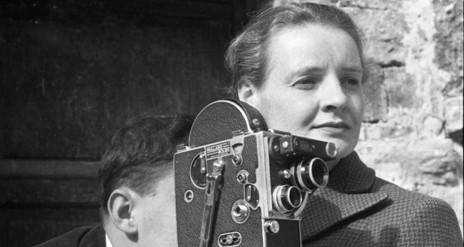 A black and white photo of Dr Margaret Caroline Tait and someone standing at her shoulder looking into the viewfinder of a camera