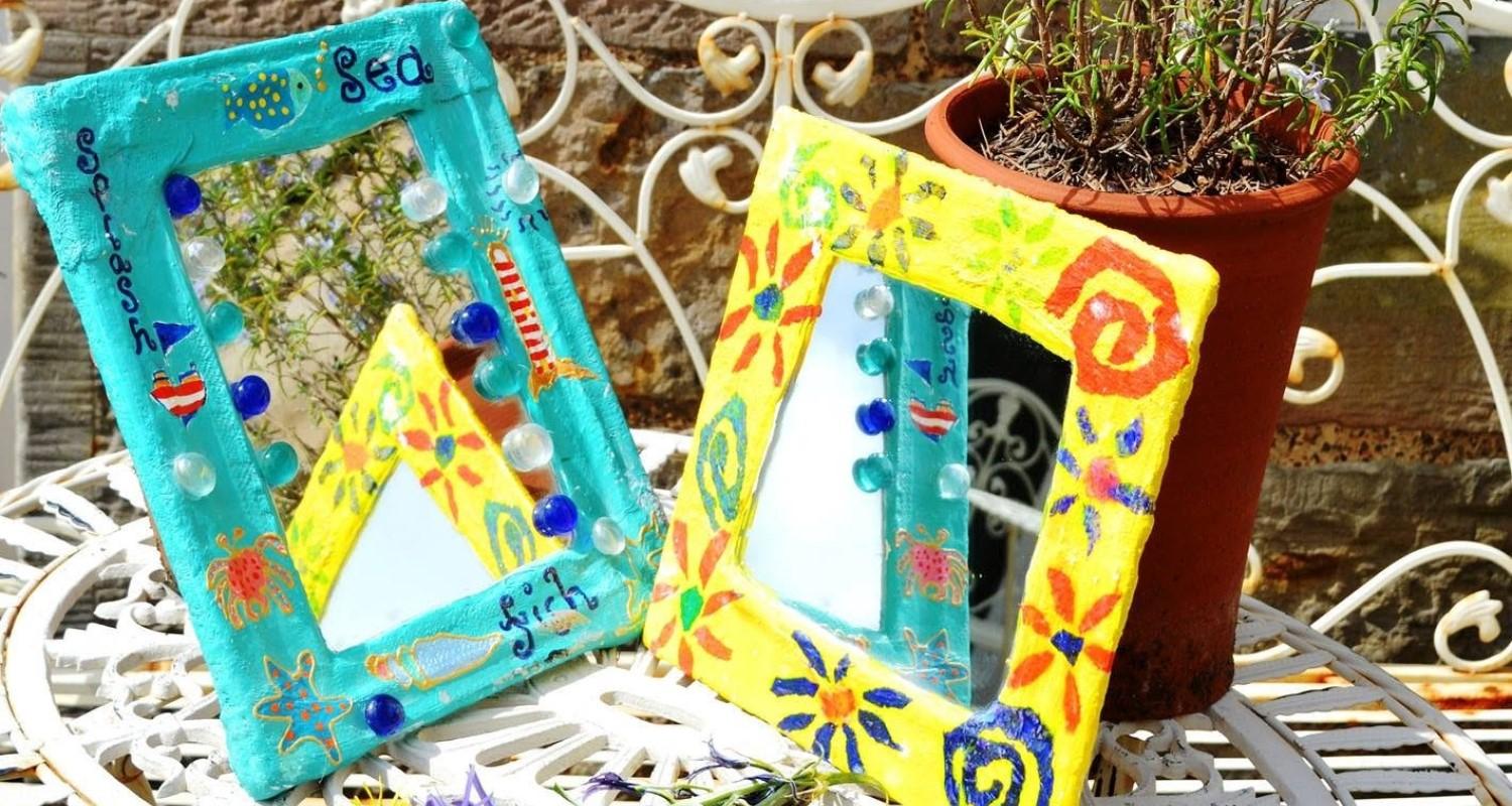 A yellow and a blue table mirror, each with a handpainted Modroc frame