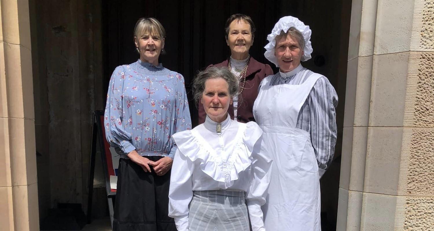 Members of Edinburgh Living History in Edwardian garb standing on the steps at the entrance to Lauriston Castle