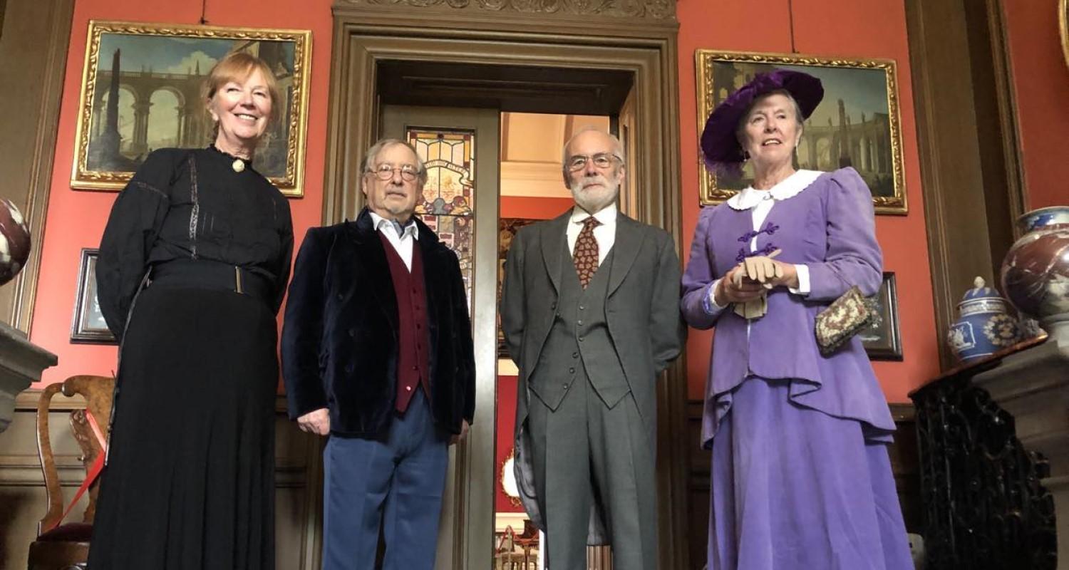 Four members of the household wearing Edwarding clothing stand in the passageway