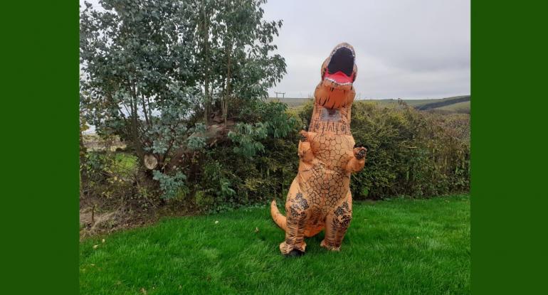 An orange T-Rex dinosaur costume in the grounds of Lauriston Castle