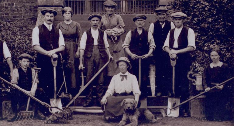 Mary Burton, her team of gardeners with shovels, hoes and garden forks, a chicken and her dog