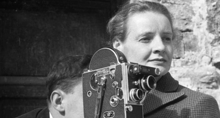 A black and white photo of Dr Margaret Caroline Tait and someone standing at her shoulder looking into the viewfinder of a camera