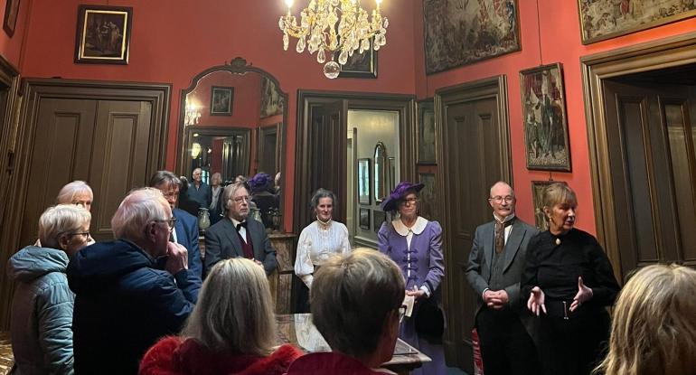 A group of visitors stand in the passage way at Lauriston Castle as Edinburgh Living Heritage, in Edwardian garb,perform 