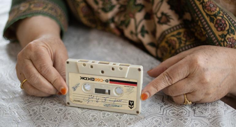 A woman's hands holding a cassette tape