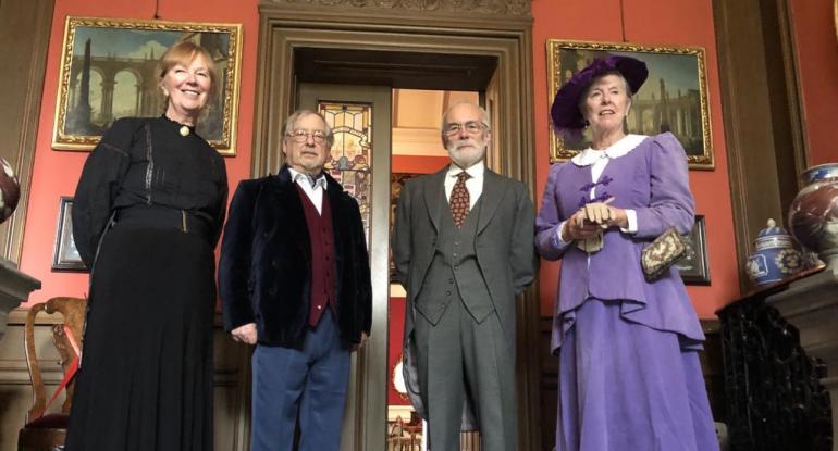 Four members of the household wearing Edwarding clothing stand in the passageway