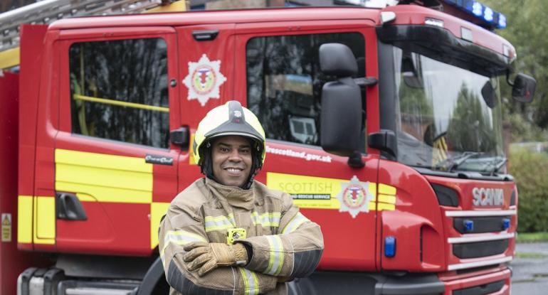 Firefighter Leroy Shaw in front of his fire engine
