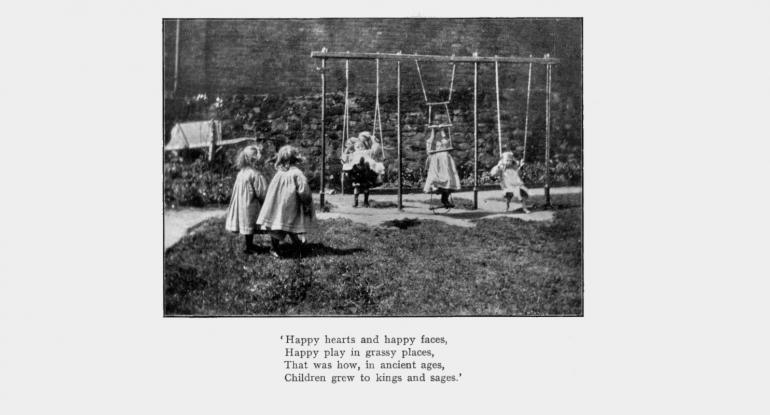 A black and white photo of three little girls perhaps in Edwardian times, playing on swings as two more look on