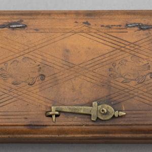 Closed wooden box with metal latch and line engraving decoration